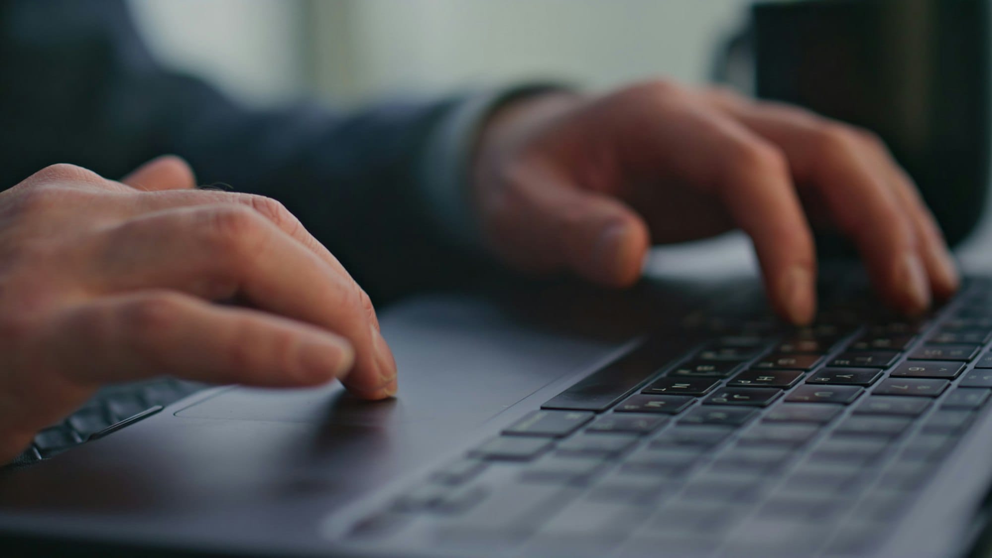 Unrecognizable writer typing keyboard laptop creating article at office closeup